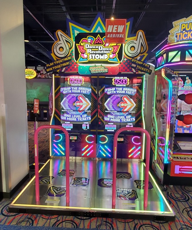 Photo of a Dance dance revolution Stomp cabinet. It's a ticket game of DDR where you just stomp on arrows to gain more tickets